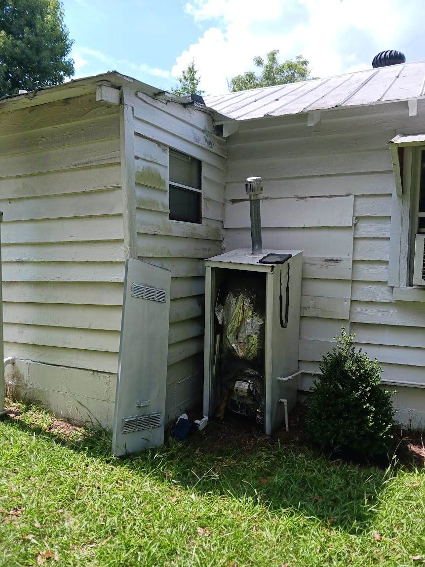 Old outdoor water heater unit needing replacement