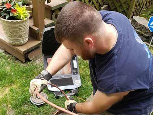 Tech using a camera for a pipe inspection